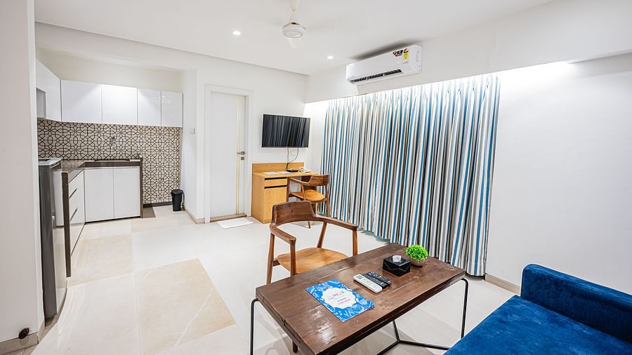 An image of a hall room featuring a sofa, chair, and a centre table, a flat TV screen, and cabinets at Indie Stays Studio, Chembur
