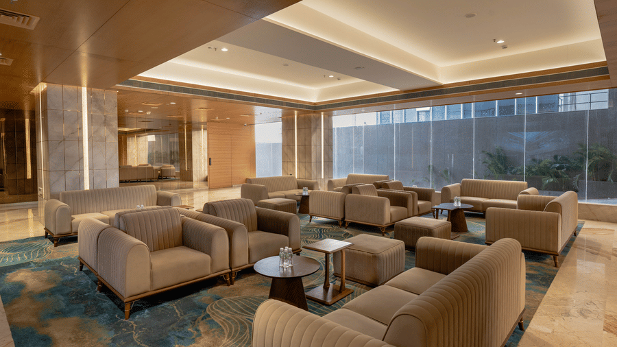 A spacious waiting area with comfortable seating clusters, marble accents, and large windows - Praveg's Grand Eulogia, Ahmedabad