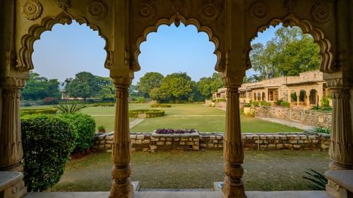 A view of the garden from an ornate arch-shaped hallway in Deo Bagh - 17th Century, Gwalior.