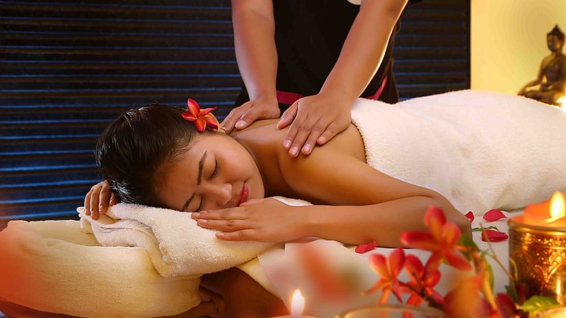 A woman lying on her stomach and receiving back massage from the masseuse at UDS Group of Hotels