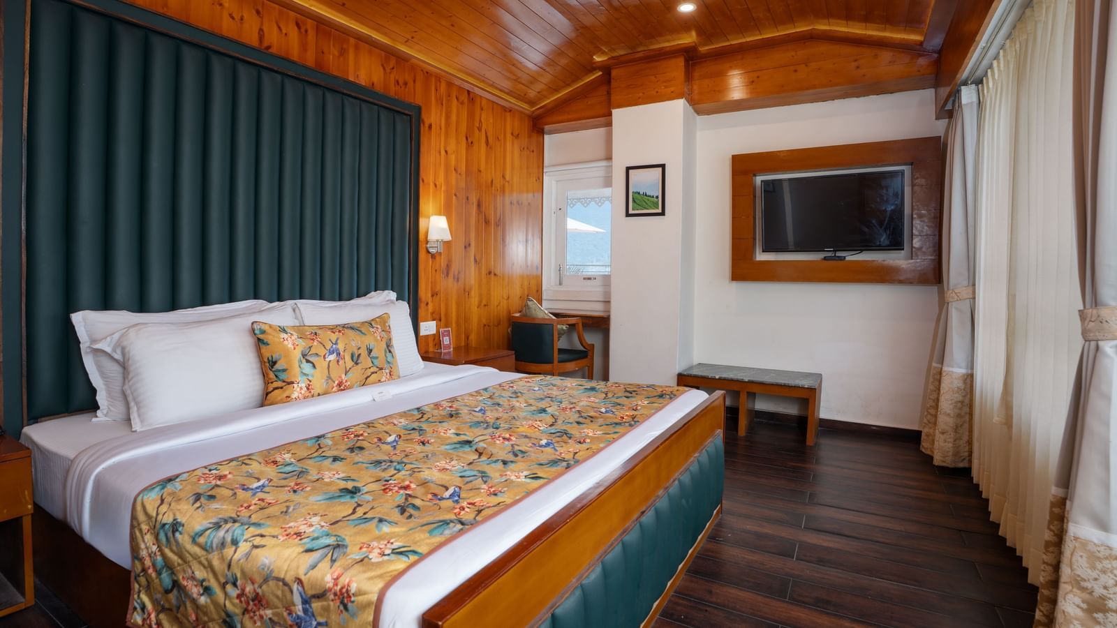 Suite at Summit North Star, Gangtok featuring a bed, a flat TV screen, bedside table, a stool, and a chair.