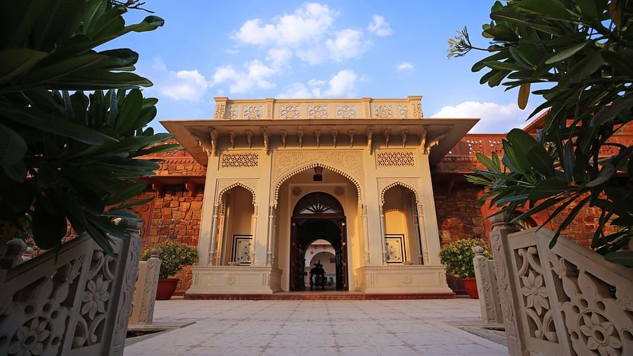 Entrance of a haveli with inticate stone carvings surrounded by trees - Khas Bagh, Jaipur
