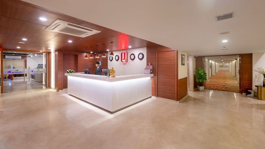 Hotel lobby entrance with reception area and wall decor including clocks and artwork - Lords Eco Inn Shapar Rajkot