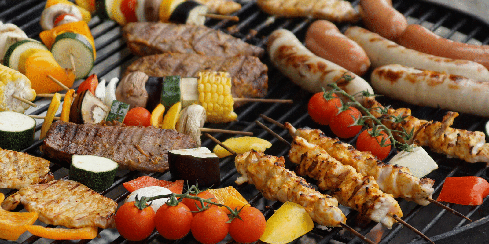 a large circular grill on which meat and vegetables are being cooked