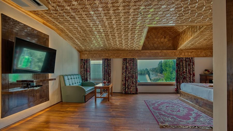 Premium bedroom at Royal Comfort Regency featuring a detailed ceiling, glass windows and peaceful ambience for guests.