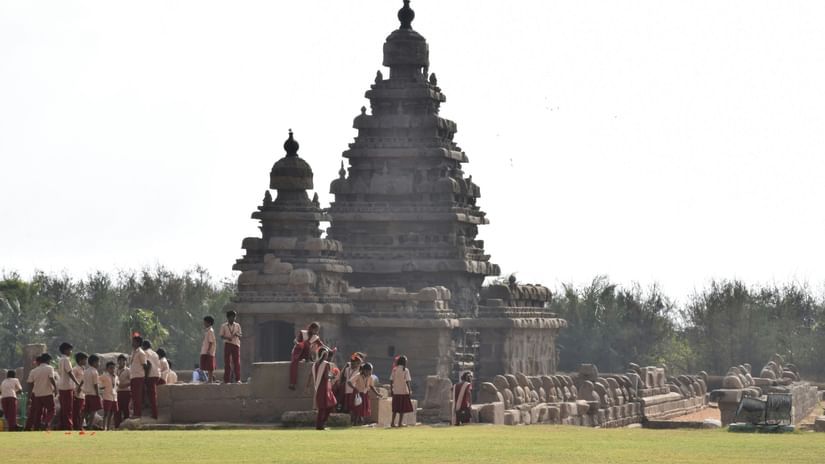 An overview of a temple with a manicured garden in the foreground having people on it in Thanjavur.