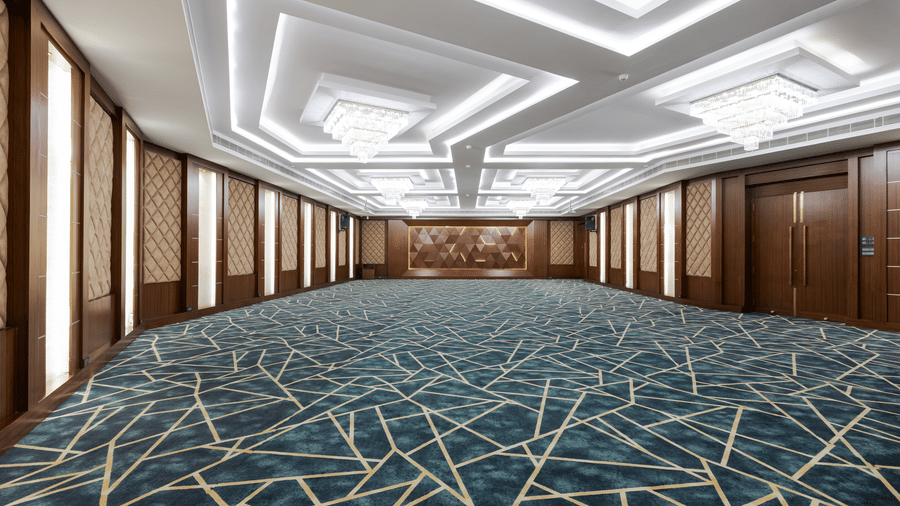 A hall at Jenneys Residency with multiple doors, chandeliers, and checkered floor.