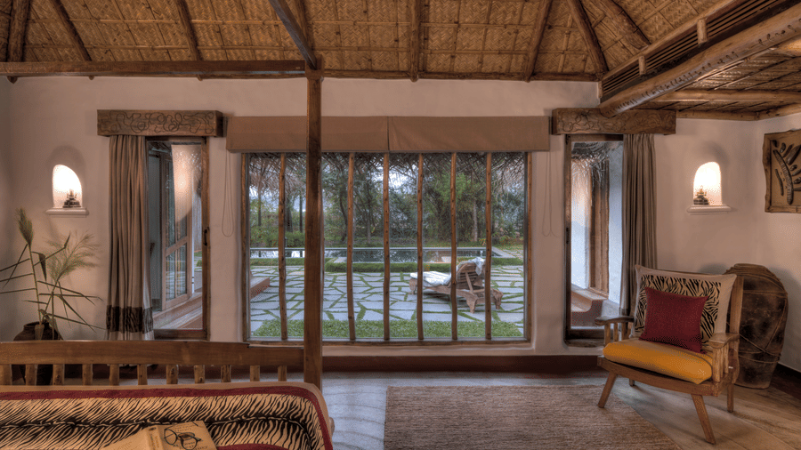 Thatched villa bedroom with river view at Evolve Back Kabini