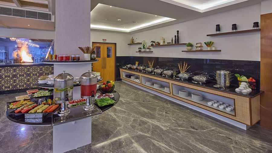 fruits, vegetables, sprouts, and beverages in the buffet area of our restaurant in Mahabalipuram - tables and chairs in our restaurant in Mahabalipuram - Grand Continent, Mahabalipuram