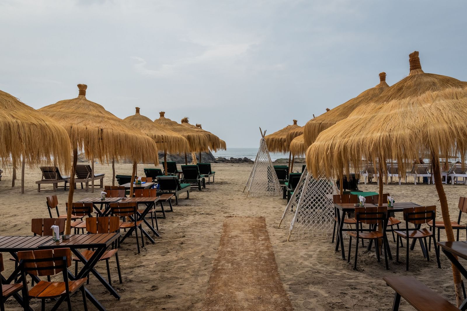 An outdoor dining setting at Love Anna Bar and Restaurant with wooden ambience at Royale Amata - By the Beach.