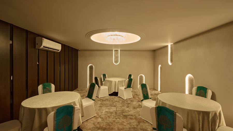 Banquet hall with round tables and elegant lighting at Voyage Milestone Hotel and Banquet.