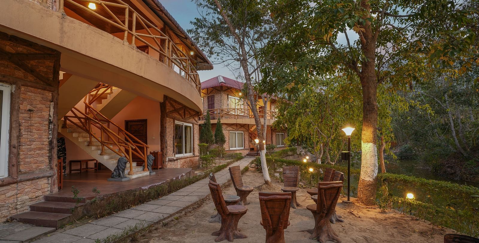 Outdoor seating area under the tree at Summit Green Lake Tea Resort & Spa, Kaziranga