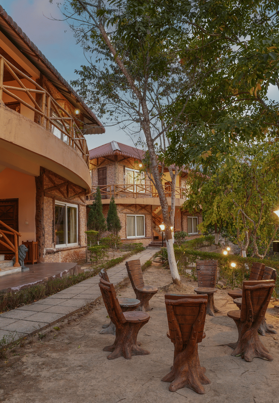 Outdoor seating area under the tree at Summit Green Lake Tea Resort & Spa, Kaziranga