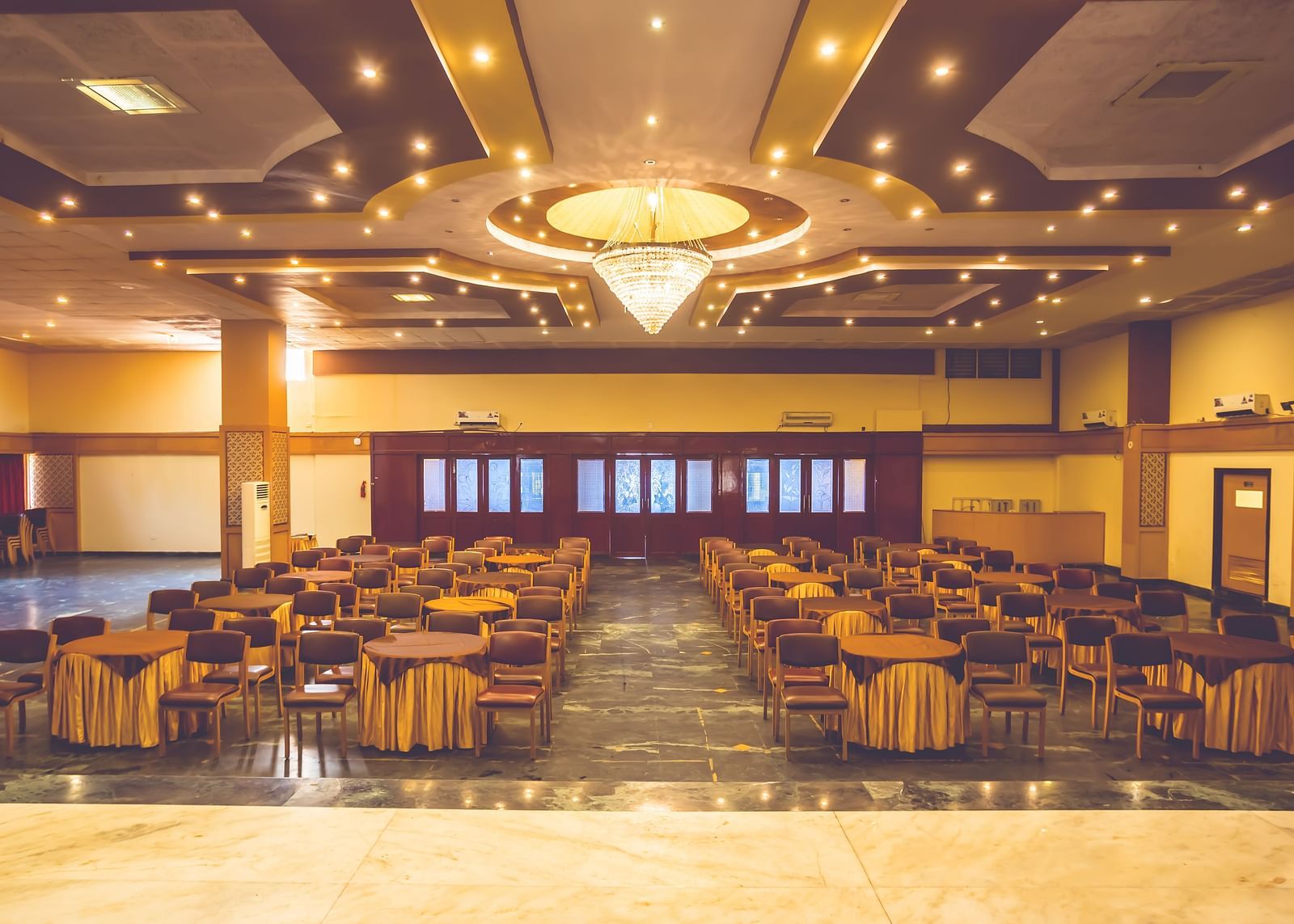 Interiors of a banquet hall at Paradise Isle Beach Resort, Udupi with a chandelier and theatre style seating under it