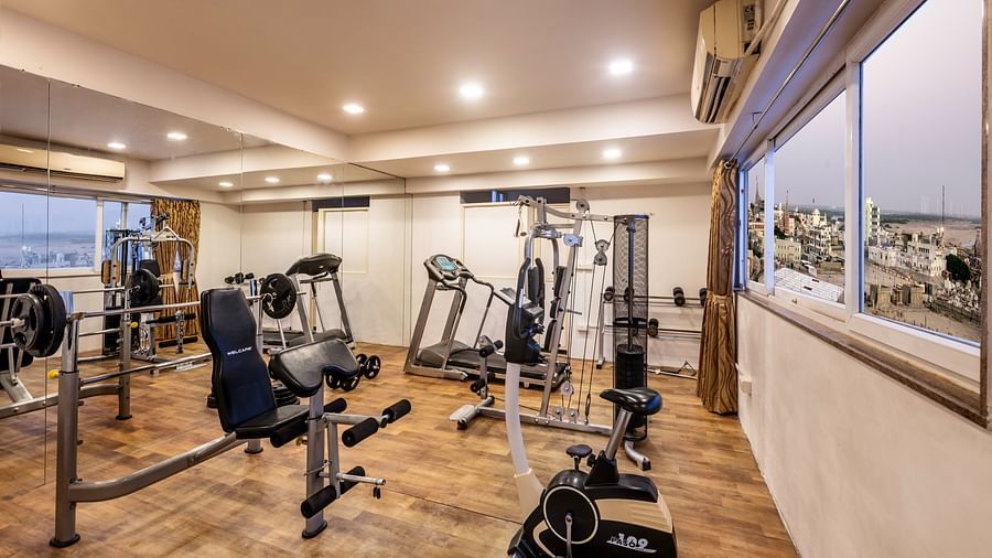 A well-equipped fitness centre with various weight machines, treadmills, and an exercise bike.