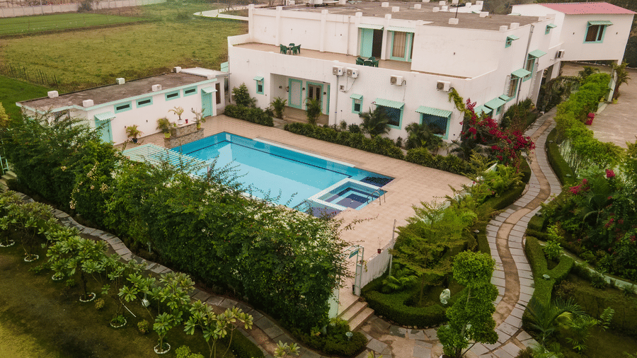 Facade of at Vedikant Resorts The Mallard Corbett featuring a multiple storey building, a lawn, and a swimming pool surrounded by trees.