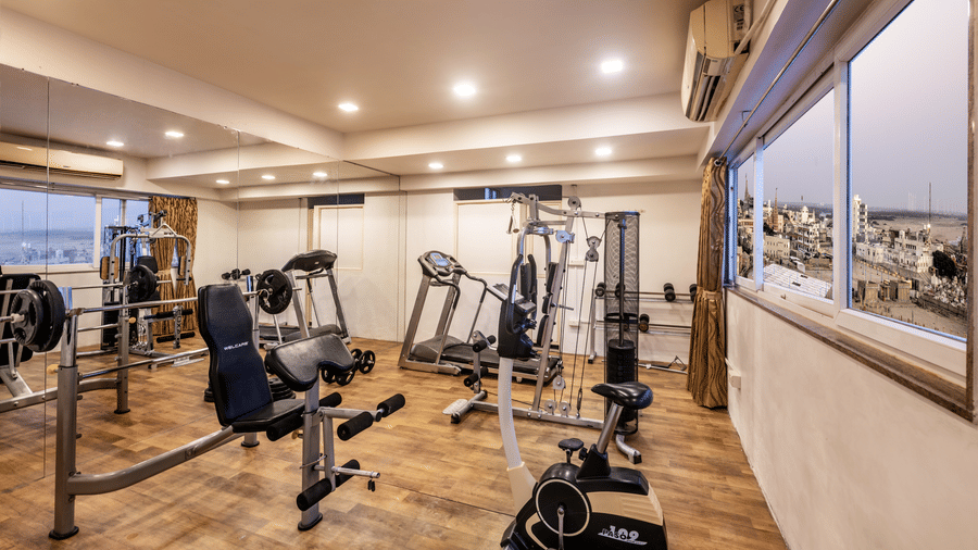 A well-equipped fitness centre with various weight machines, treadmills, and an exercise bike.
