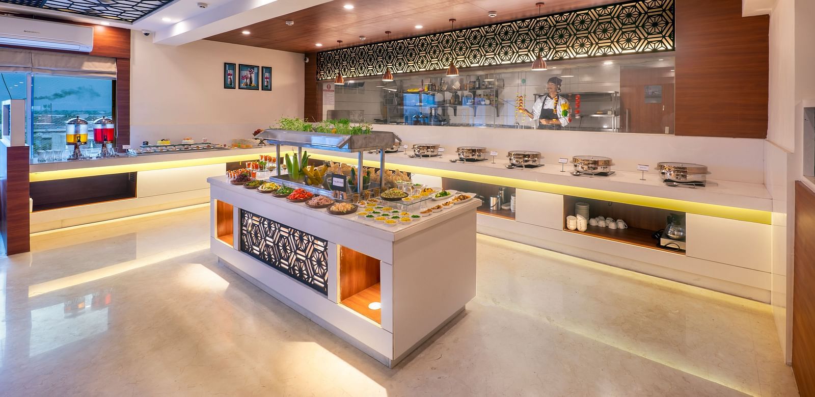 A hotel reception area with a brightly lit counter and a person standing behind it, along with decorative clocks on the wall.