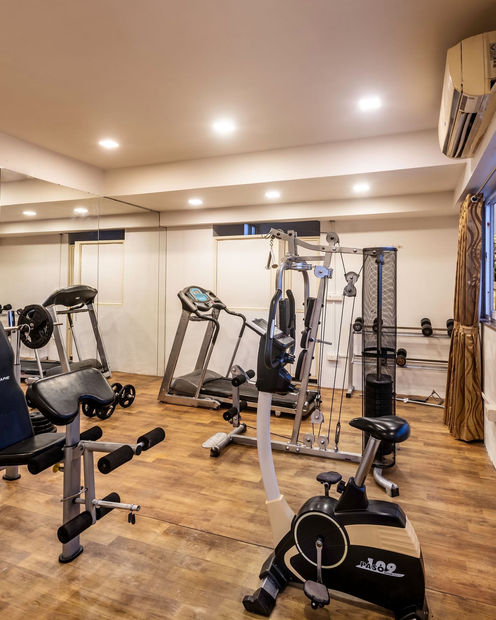 A well-equipped fitness centre with various weight machines, treadmills, and an exercise bike.