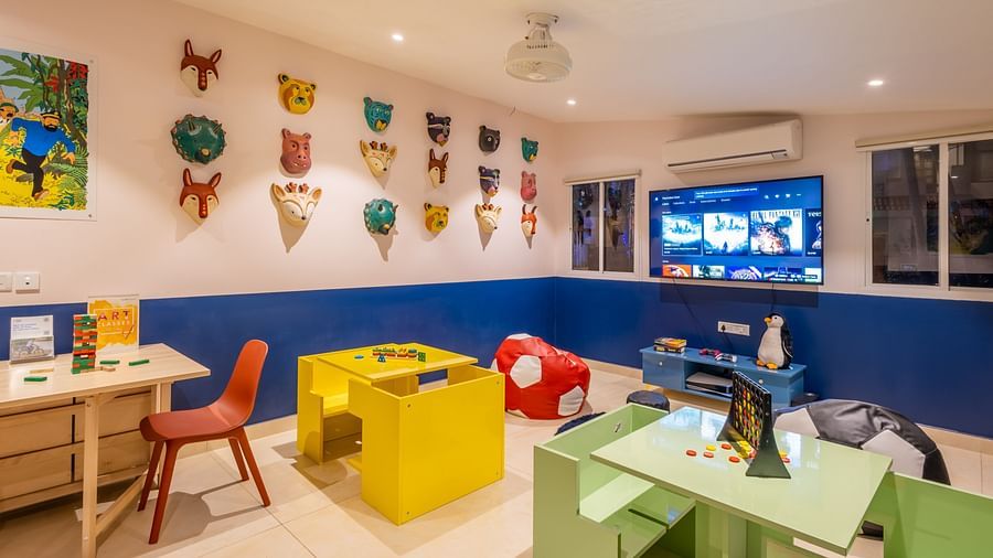 The interiors of Rumpus featuring table-chair sets a TV decorative masks on walls and toys