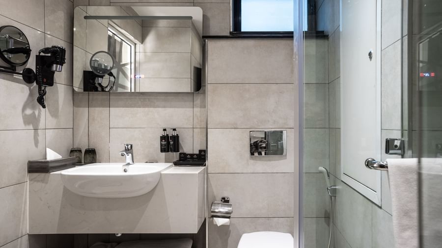 Bathroom with shower, toiletries, vanity counter, and glass partition at Best Western Premier Westlands hotel.