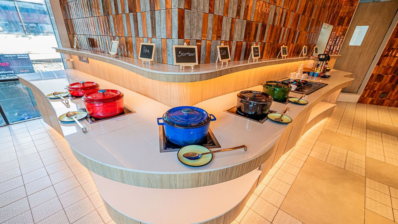 A spacious counter on both sides, adorned with numerous vessels placed at equal distances, complemented by warm lighting at  Indie Stays Mumbai International Airport.