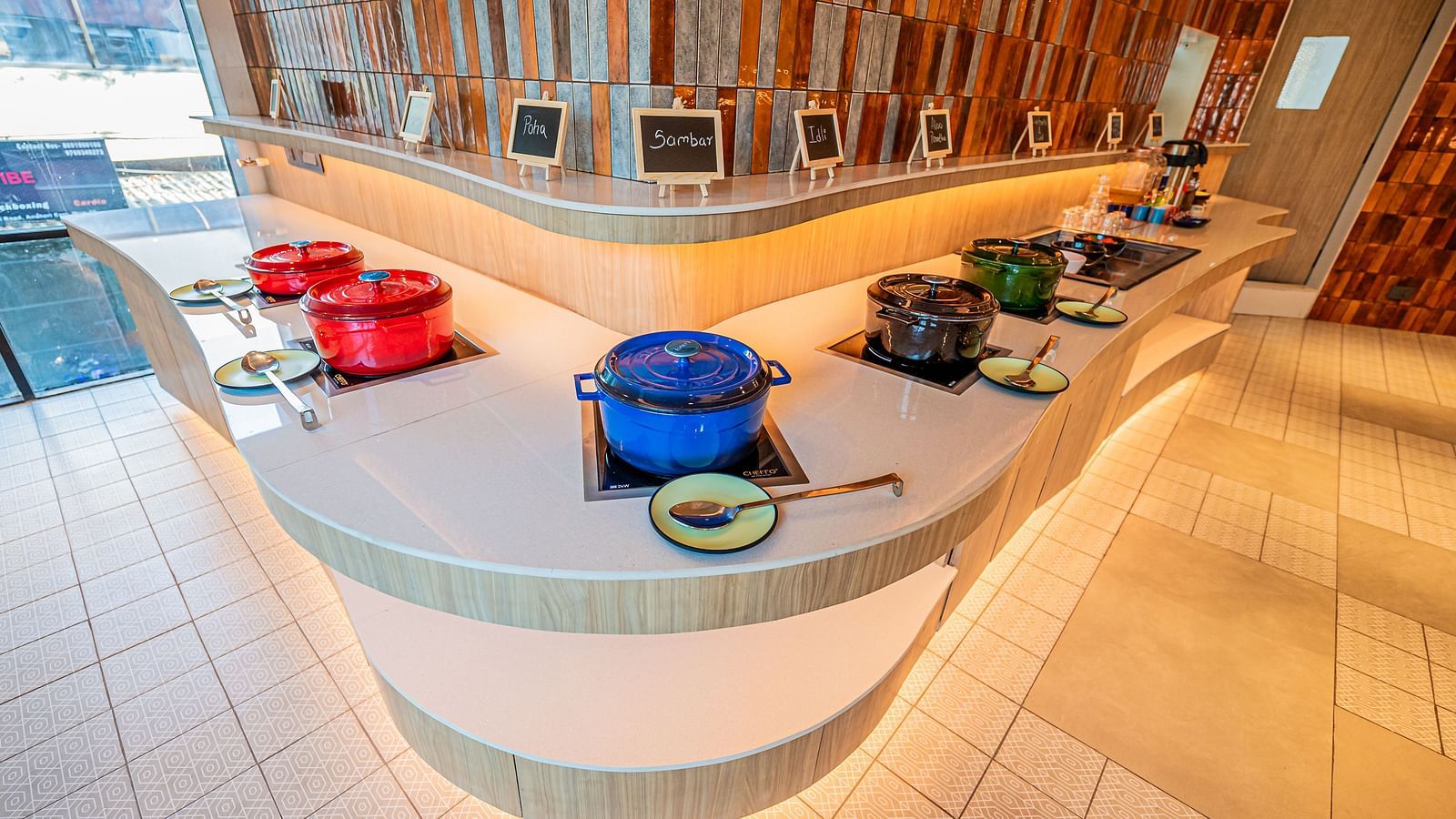 A spacious counter on both sides, adorned with numerous vessels placed at equal distances, complemented by warm lighting at  Indie Stays Mumbai International Airport.