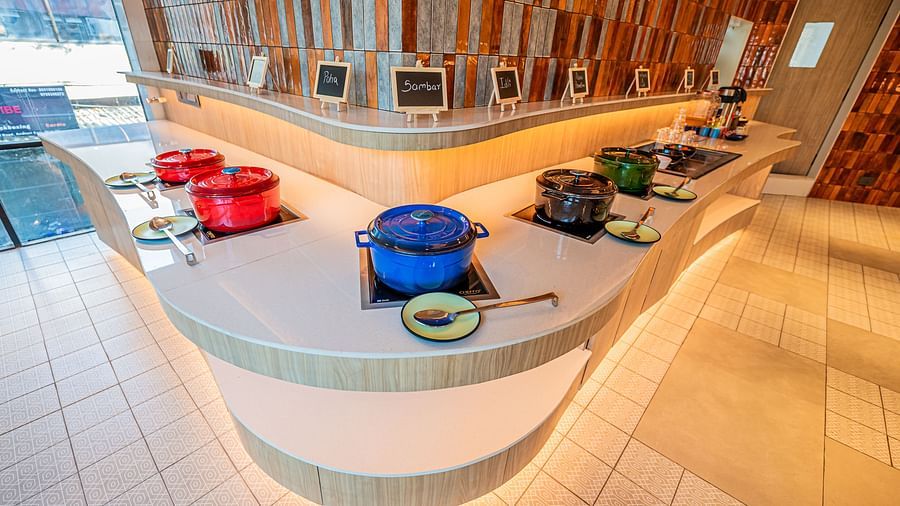 A spacious counter on both sides, adorned with numerous vessels placed at equal distances, complemented by warm lighting at  Indie Stays Mumbai International Airport.