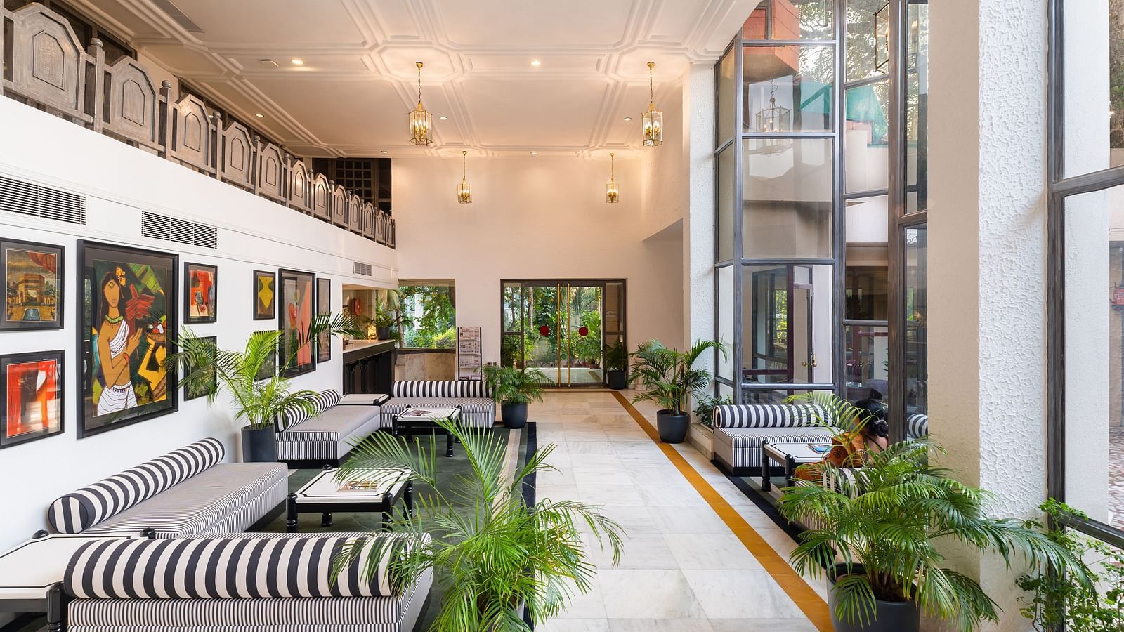 the lobby at our hotel with black and white stripped sofas, wall decor, indoor plants and lighting - Hotel Rajdarshan, Udaipur.