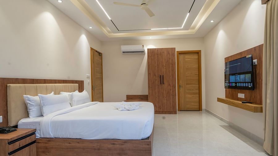 a double bed and television in the luxury room with bathtub at Corbett Four Seasons, Ramnagar