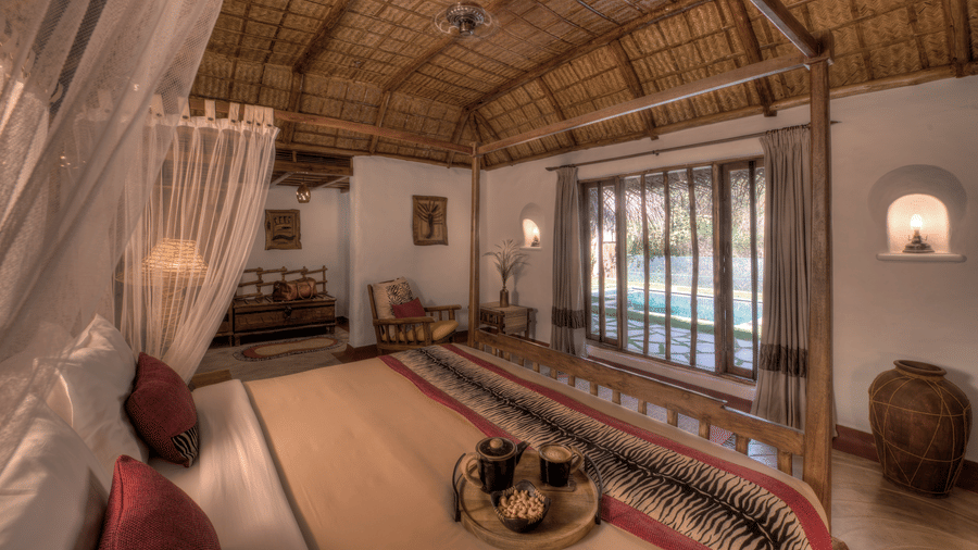 Spacious thatched villa bedroom interior at Evolve Back Kabini