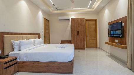 a double bed and television in the luxury room with bathtub at Corbett Four Seasons, Ramnagar