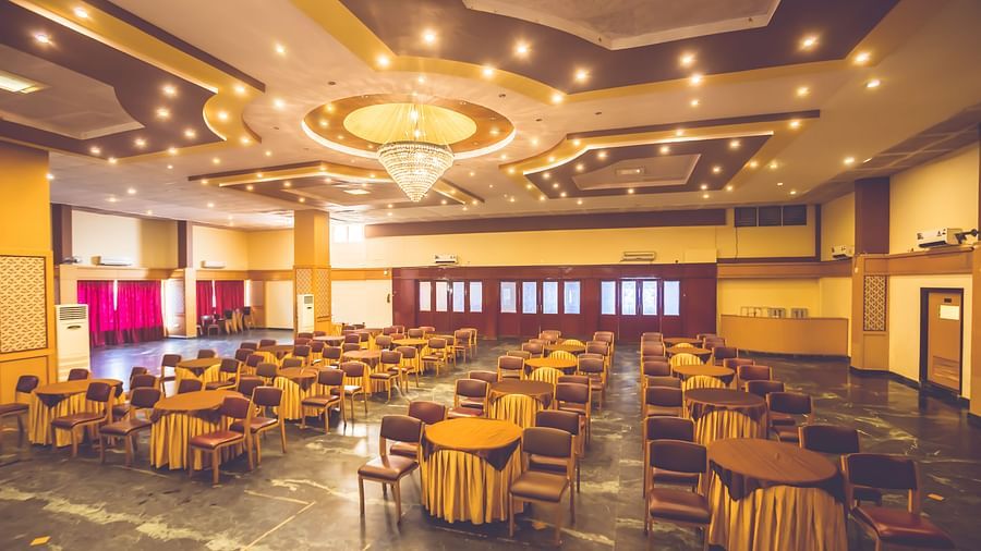 Seating arrangement in a banquet hall at Paradise Isle Beach Resort, Udupi with chairs and tables
