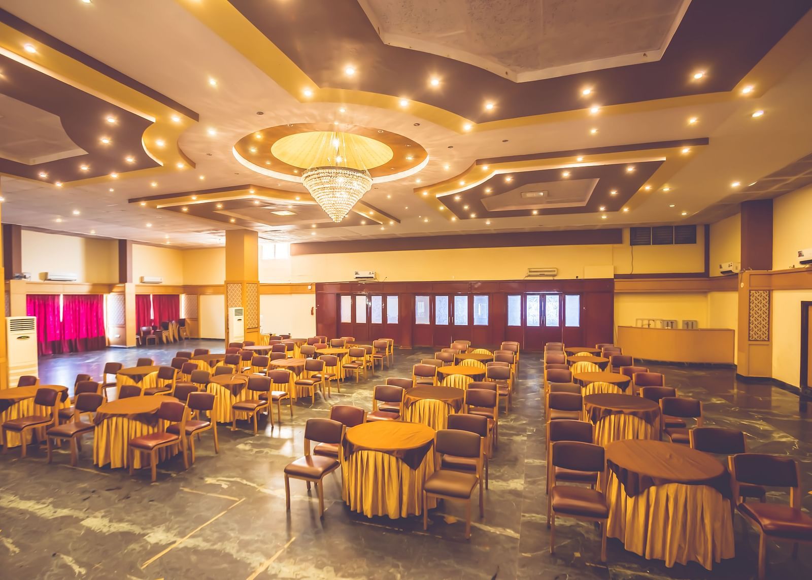 Seating arrangement in a banquet hall at Paradise Isle Beach Resort, Udupi with chairs and tables