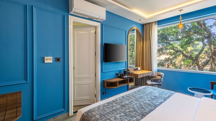A bedroom with blue walland a bed | Renest Calangute, Goa