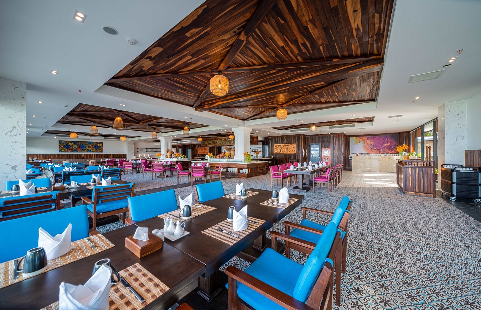 A modern restaurant at our hotel with blue chairs and a wooden ceiling - Alibu Resort Nah Trang