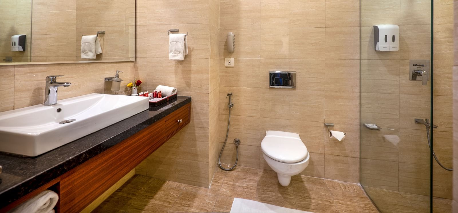 A modern bathroom with a sink, toilet, and glass-enclosed shower.