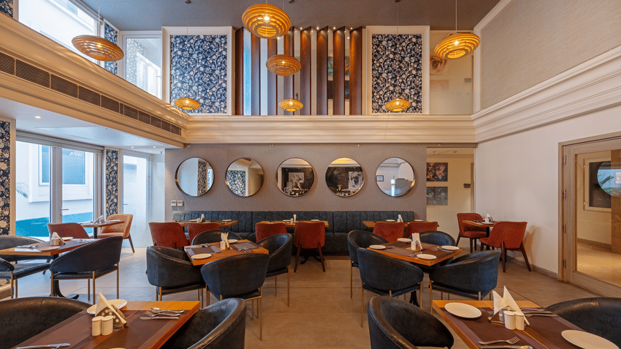 A front view of the dining area reveals large square windows split into three sections, covering the entire wall, bathing the space in natural light.