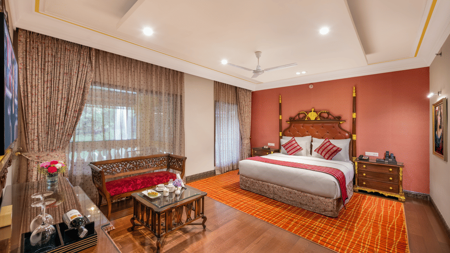 Vibrant deluxe bedroom with red accents and warm wooden decor at Mayfair Lagoon