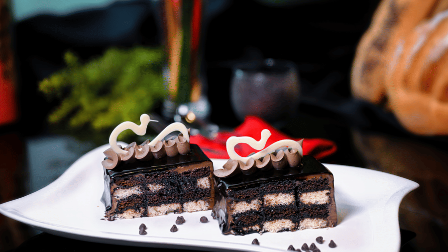 A well-decorated cake placed on a plate at Clarks Hotels.