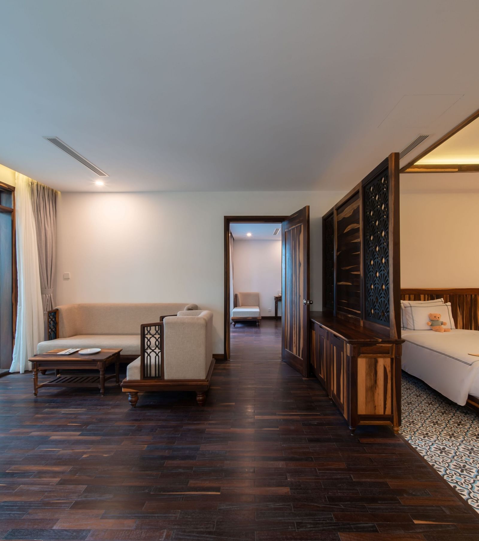 A hotel room with a separate living area near the bedroom and a balcony - Alibu Resort Nha Trang