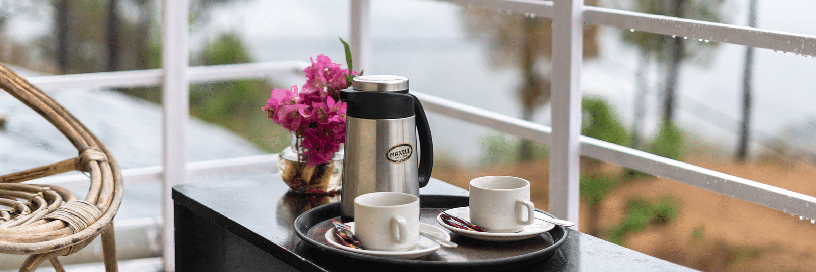 kettle and flower vase placed on a table in the balcony of Flutter Hotels & Resorts