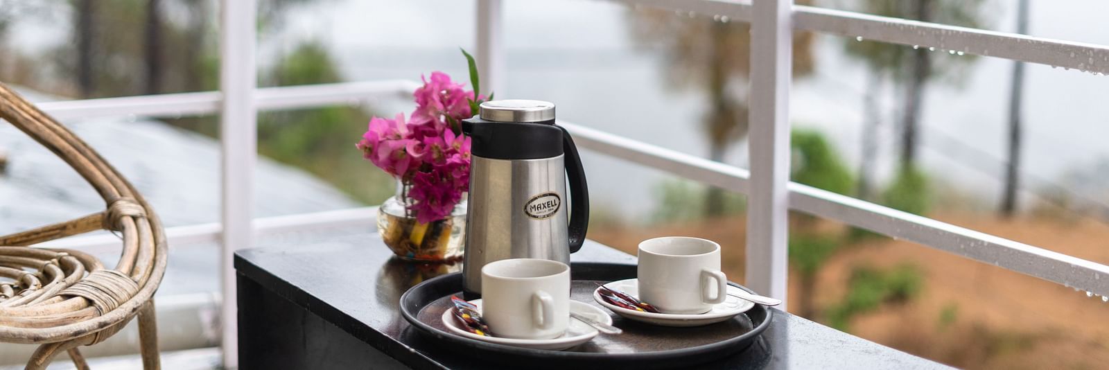 kettle and flower vase placed on a table in the balcony of Flutter Hotels & Resorts