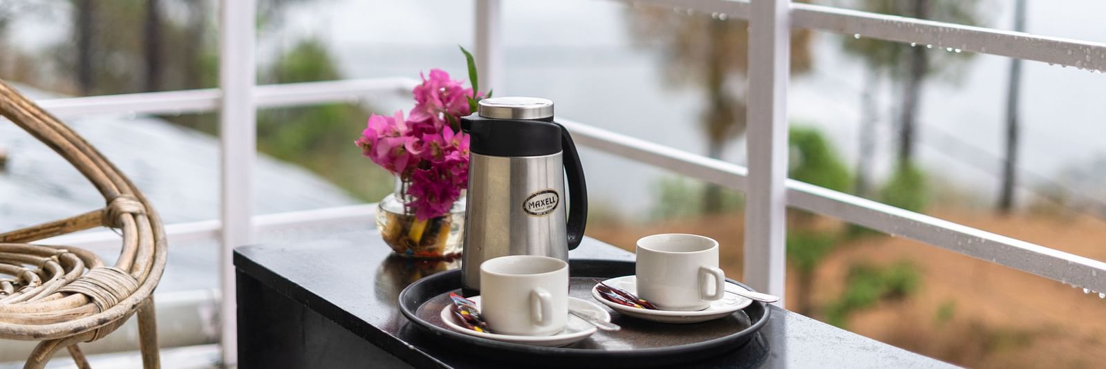 kettle and flower vase placed on a table in the balcony of Flutter Hotels & Resorts