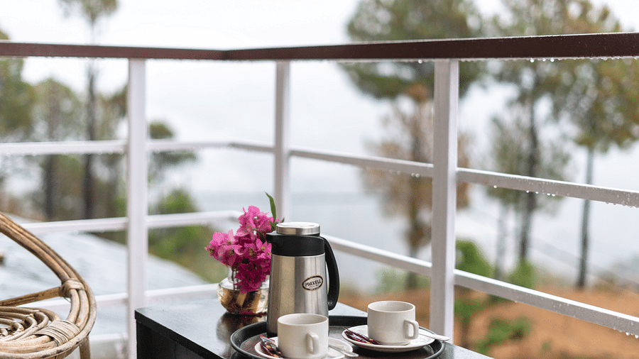 kettle and flower vase placed on a table in the balcony of Flutter Hotels & Resorts