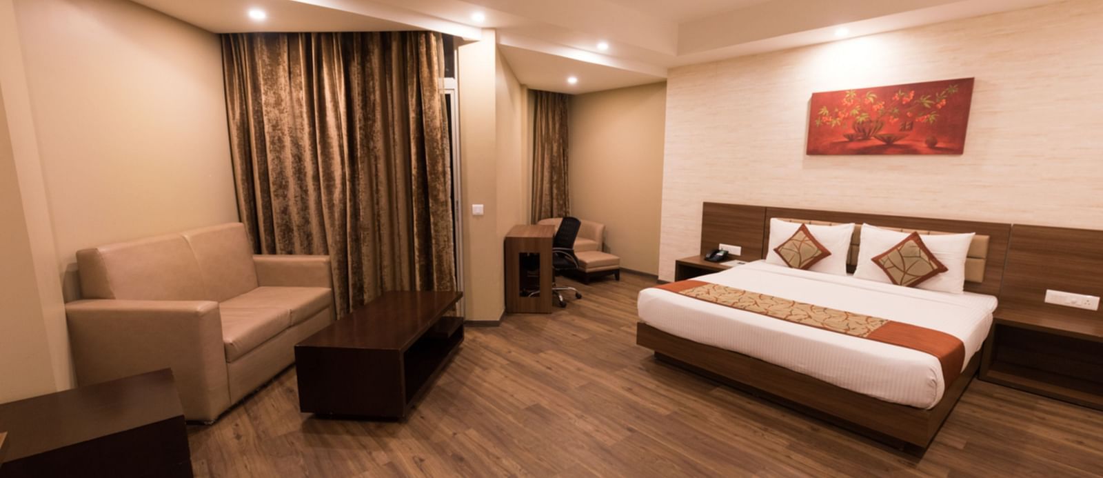 Super Deluxe Rooms with Complimentary Wi-Fi captured with a cosy bed and white linens along with a beige couch - Le ROI Digha Hotel West Bengal1