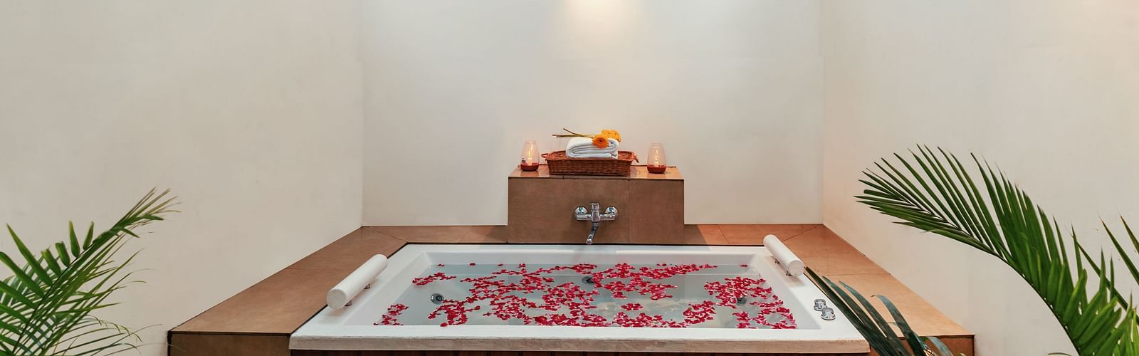 image of the outdoor Jacuzzi at the luxury suite villa at aranya vilas with rose petals floating in the water