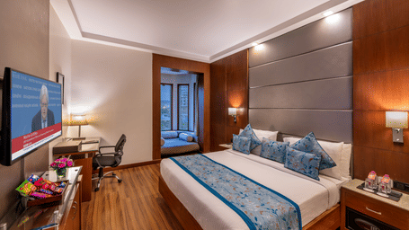 Pavilion Room with wooden flooring, flat screen TV, sitting area and bright lighting Lords Plaza Jaipur.