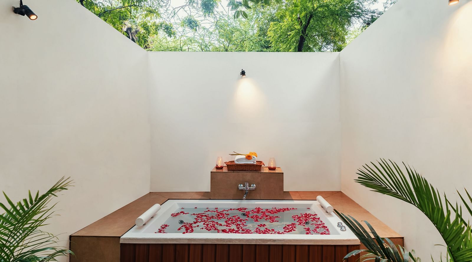 image of the outdoor Jacuzzi at the luxury suite villa at aranya vilas with rose petals floating in the water