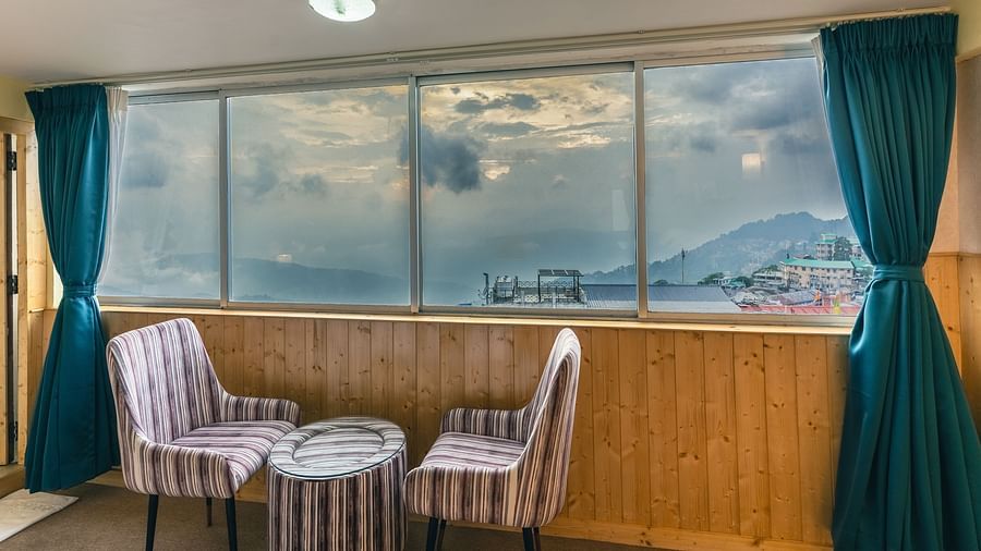 Suite with two sofa and table beside the large window at Avianna Seven Seas, Darjeeling